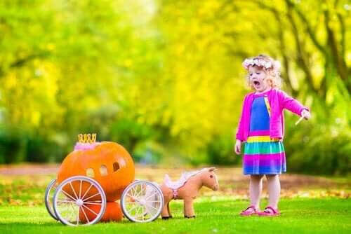 leka i trädgården: flicka med vagn av pumpor