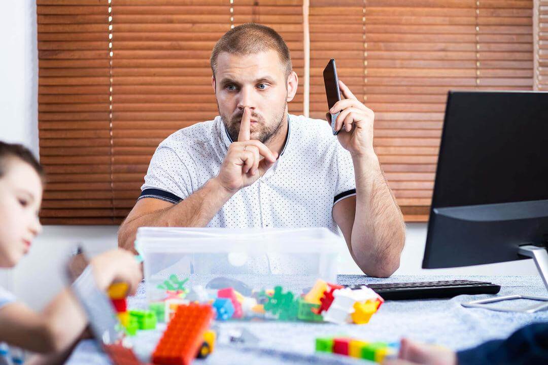 Uppstudsiga barn: pappa på telefon säger shhh till lekande barn