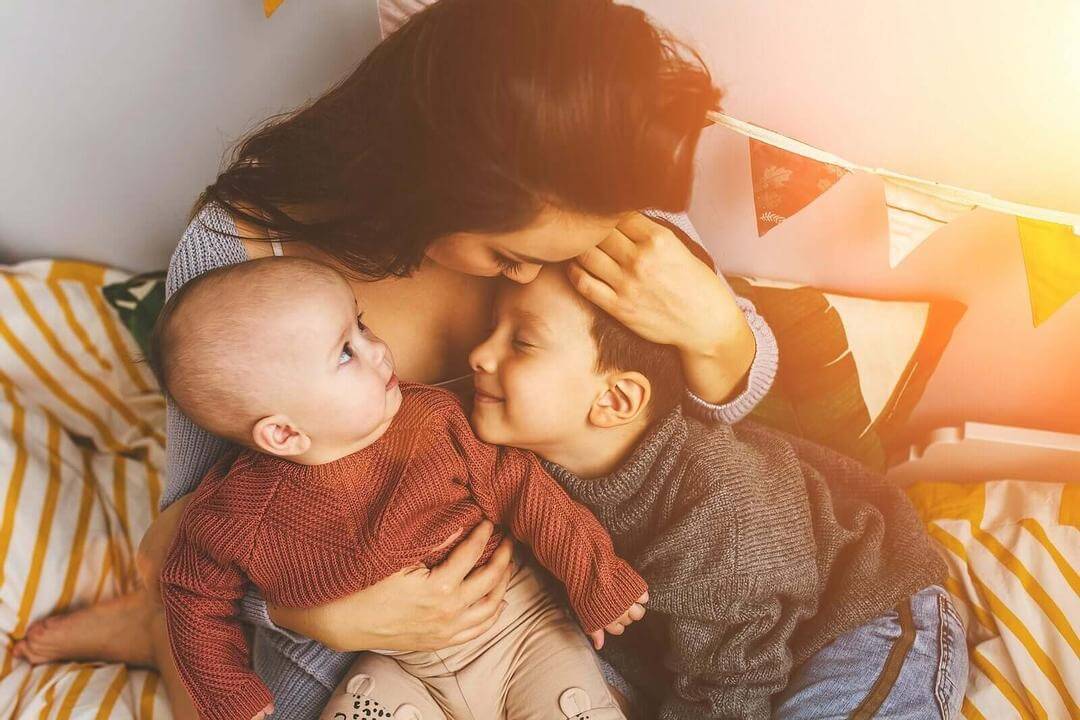 lyckliga föräldrar: mamma gosar med baby och barn