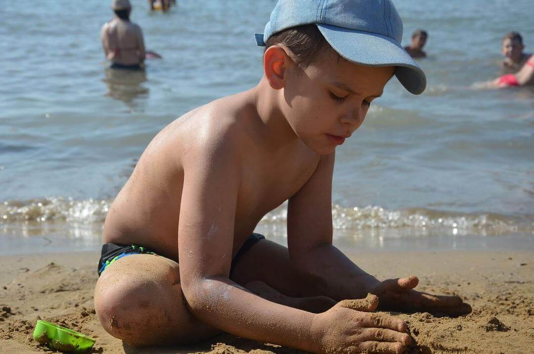 göra vid drunkning: barn bygger sandslott på stranden