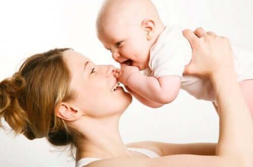 emotionell utveckling hos barn: mamma håller upp baby