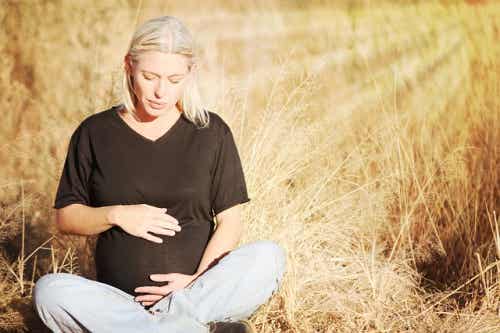 att föda barn: sittande gravid kvinna