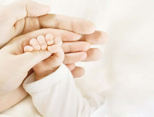 pappans roll vid amningen: pappa håller babyhand
