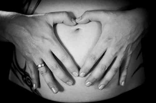 gravid kvinna med händerna på magen