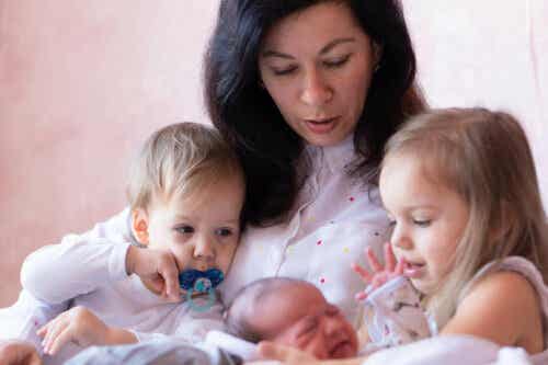 hälsa på en nyfödd: mamma med nyfödd baby och två äldre syskon