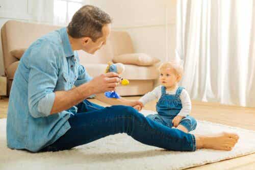 stärka barns kommunikationsförmågor: pappa leker med baby