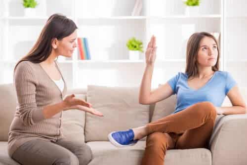 Ungdomar vill ha vår kärlek: tonåring håller upp hand mot mamma