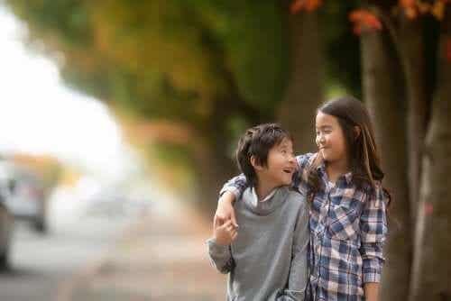 Syskon håller om varandra medan de promenerar.