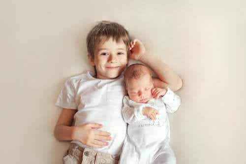 Glad storebror ligger bredvid sitt nya syskon.
