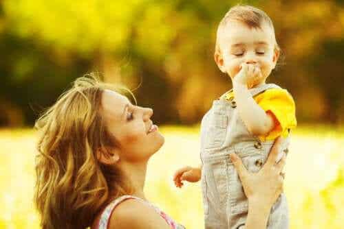 Stimulera språkutvecklingen: En mamma leker med sitt barn på en äng. 